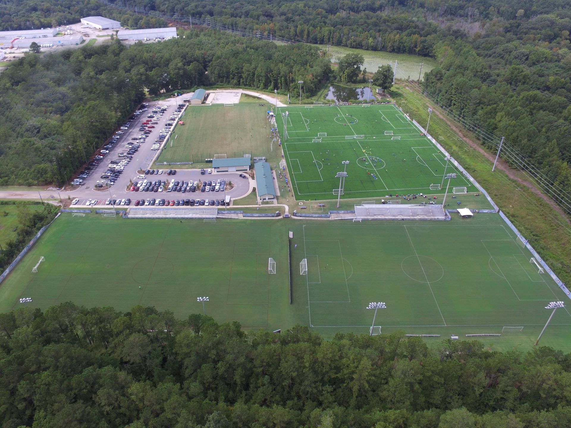 An aerial view of SCUFC's soccer fields surrounded by trees and a parking lot.