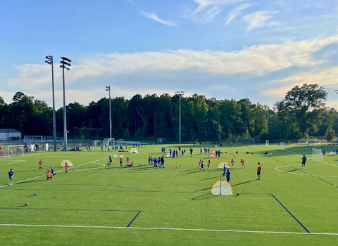 A group of people are playing soccer on a field during SCUFC's Training Corps Program.