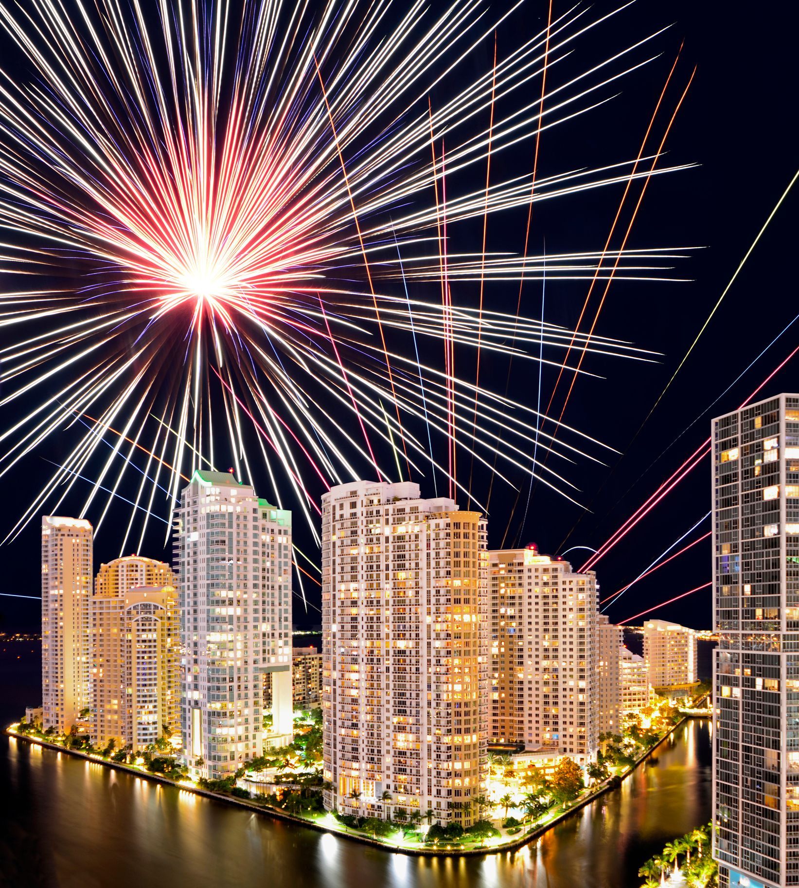 Modern white living room with a beige sectional sofa, arched windows, and a geometric patterned armchair.