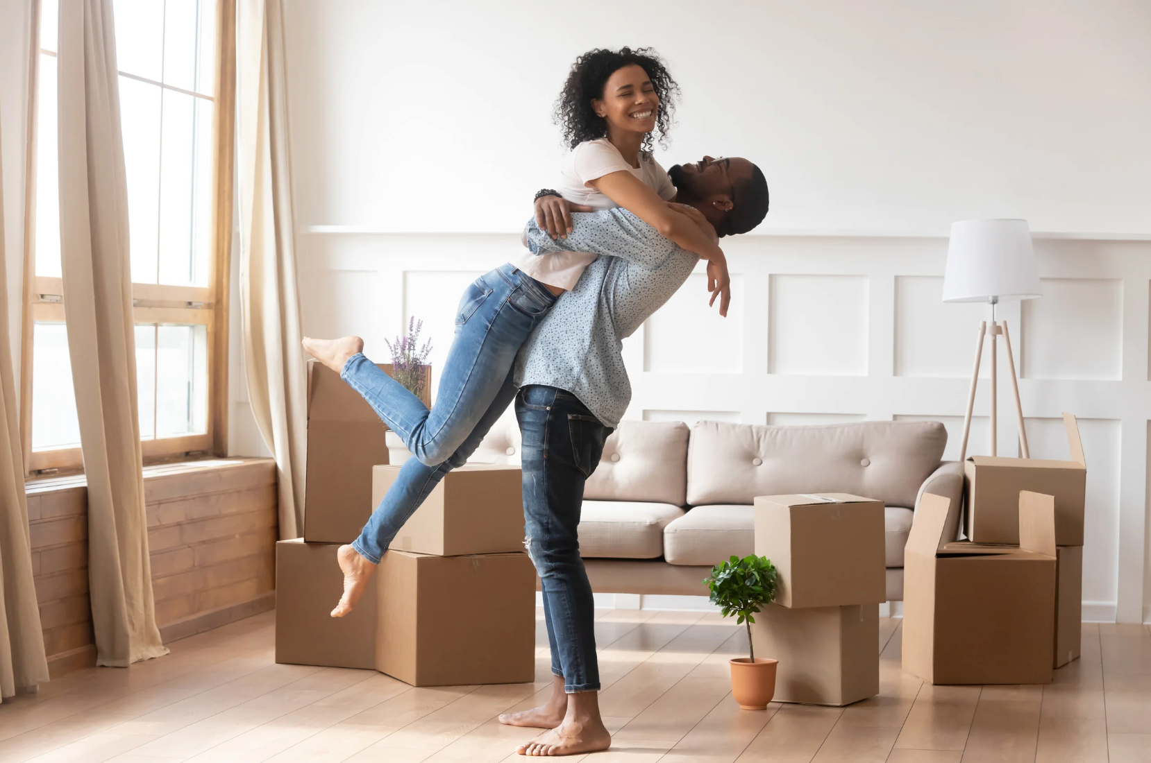 Modern white living room with a beige sectional sofa, arched windows, and a geometric patterned armchair.