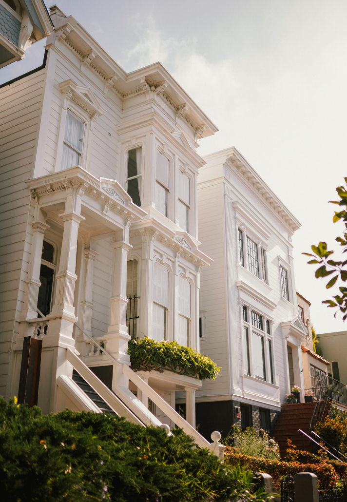 Modern white living room with a beige sectional sofa, arched windows, and a geometric patterned armchair.