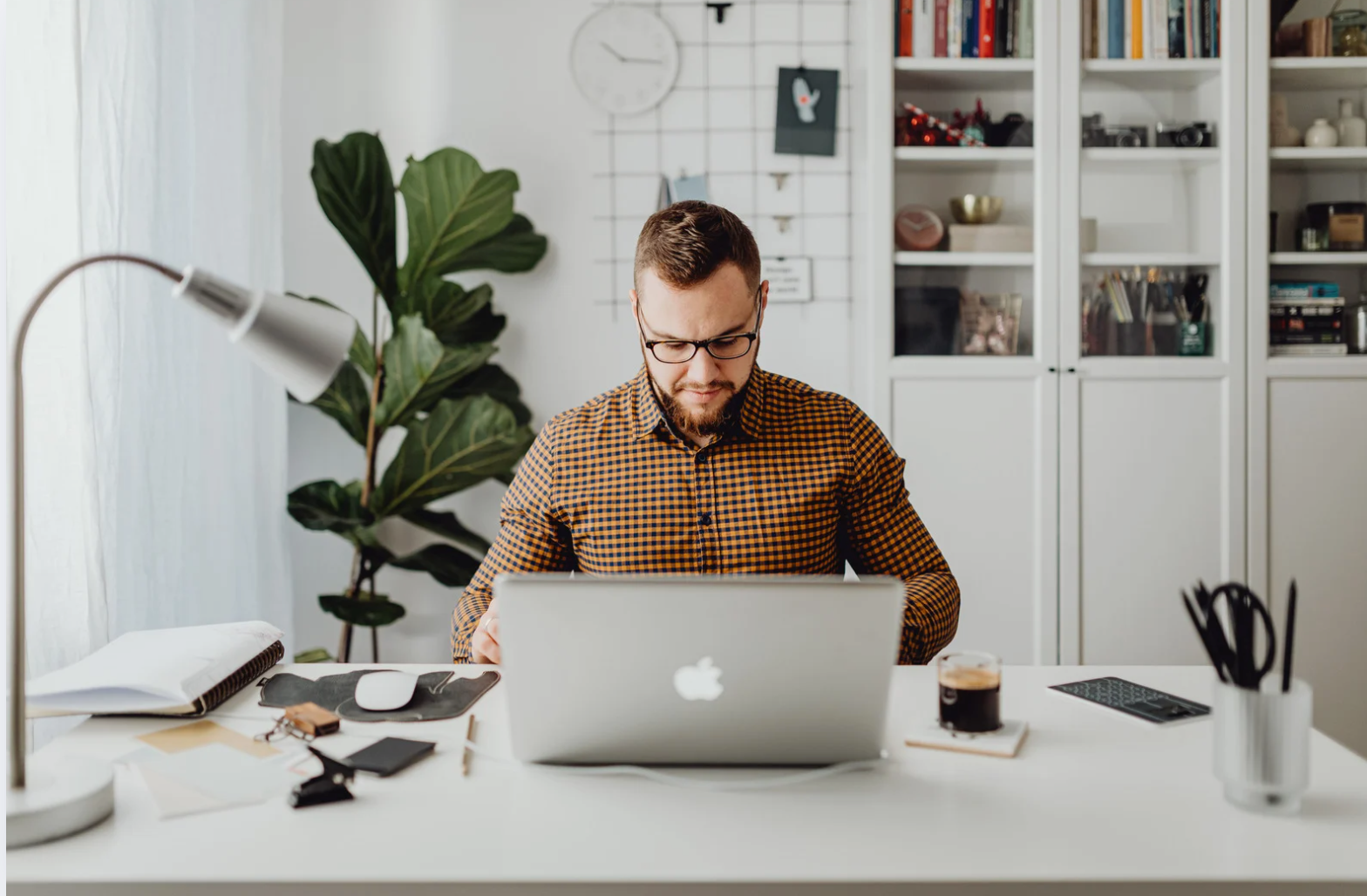 Modern white living room with a beige sectional sofa, arched windows, and a geometric patterned armchair.