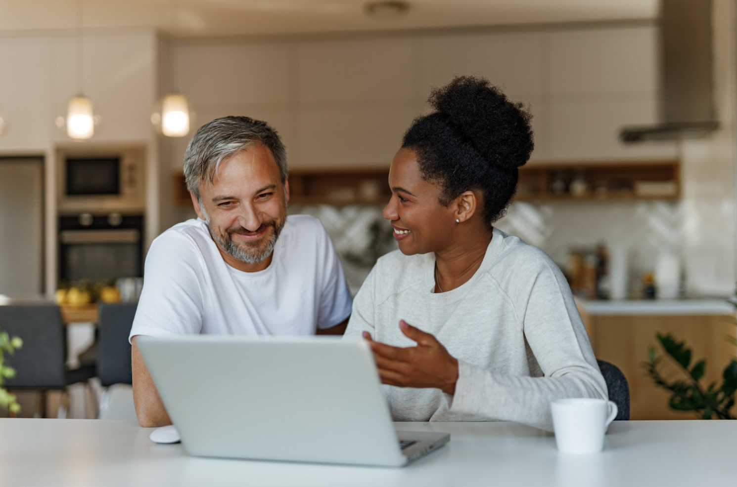Modern white living room with a beige sectional sofa, arched windows, and a geometric patterned armchair.