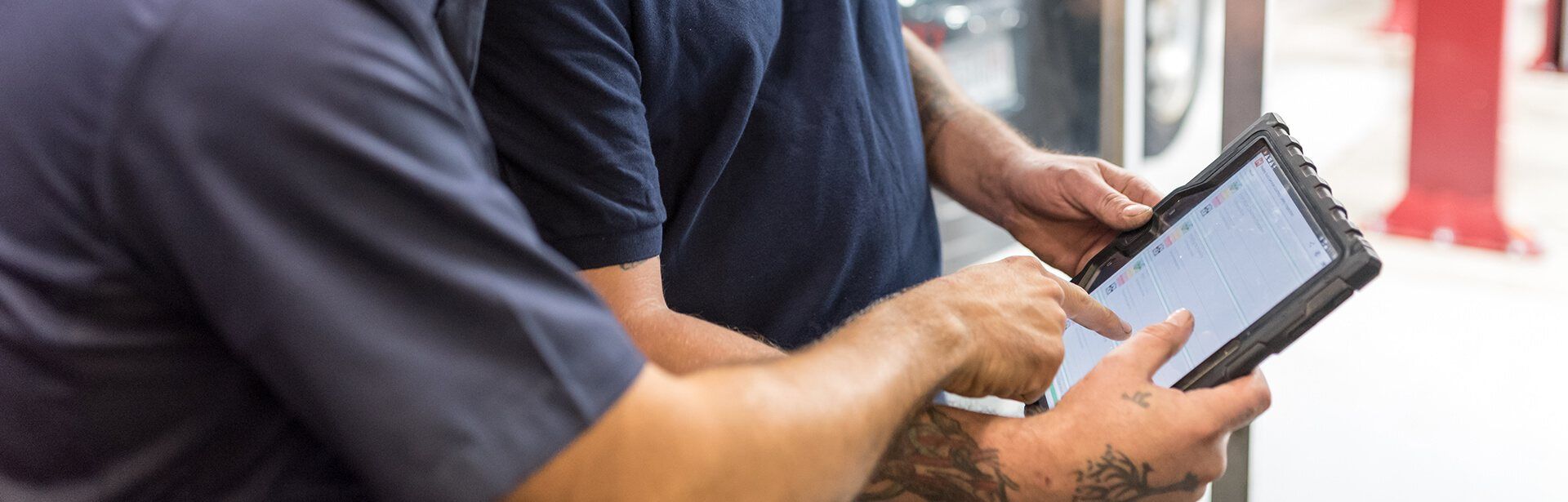 Two men are looking at a tablet together | Nealey Tire & Auto