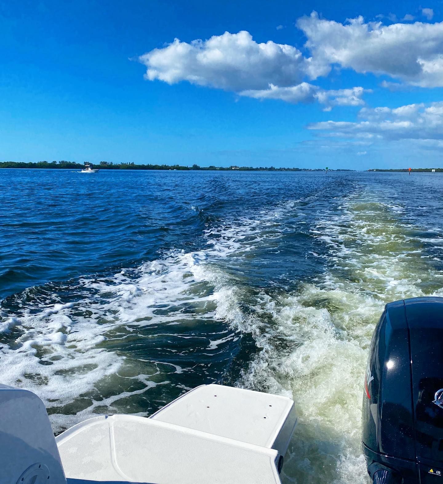 A boat is going through the water on a sunny day