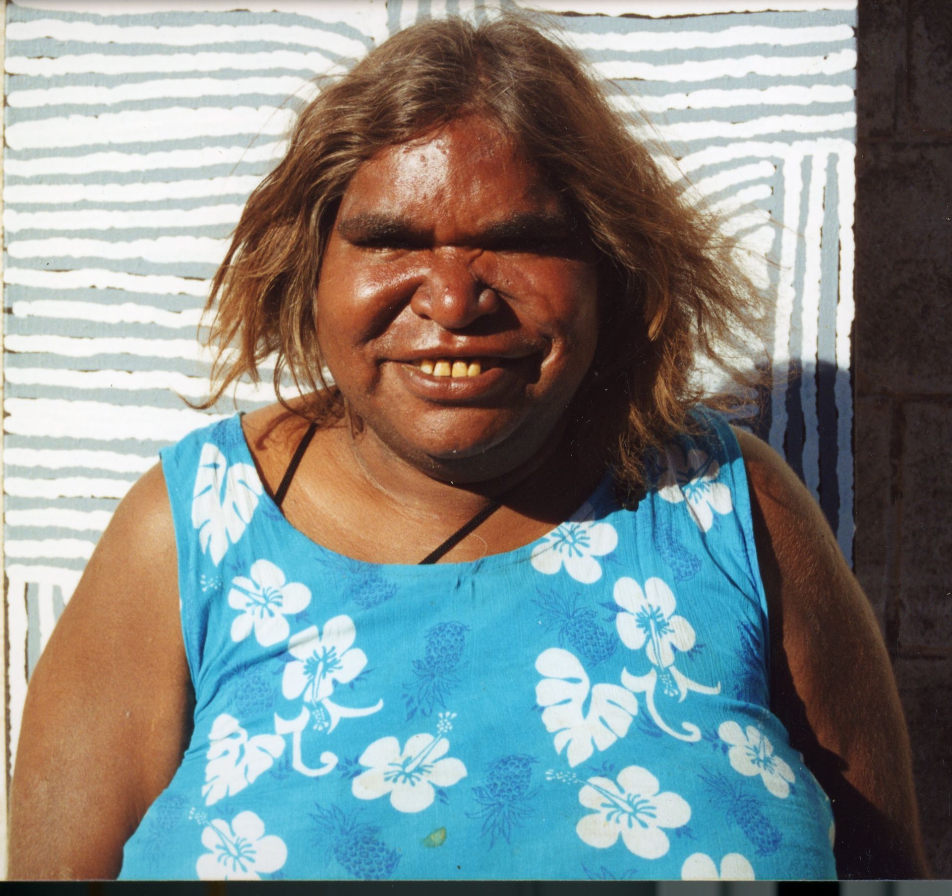 A woman wearing a blue tank top with white flowers on it