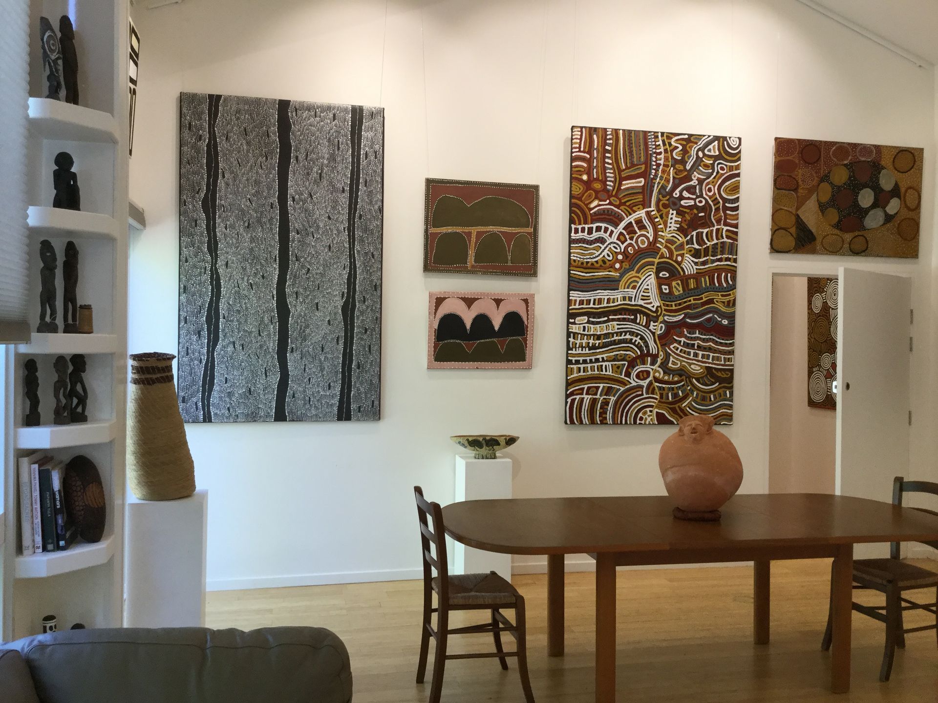 A living room with a table and chairs and paintings on the wall