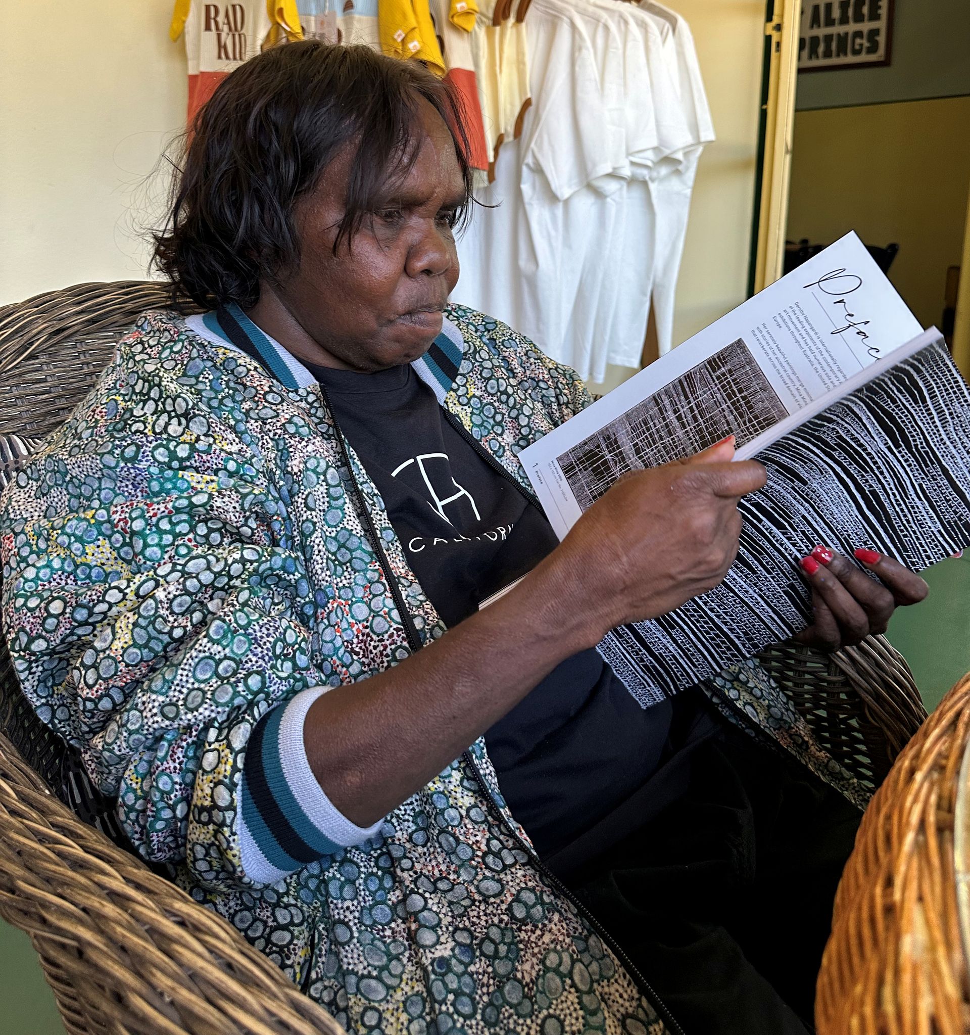 A woman is sitting in a chair reading a book