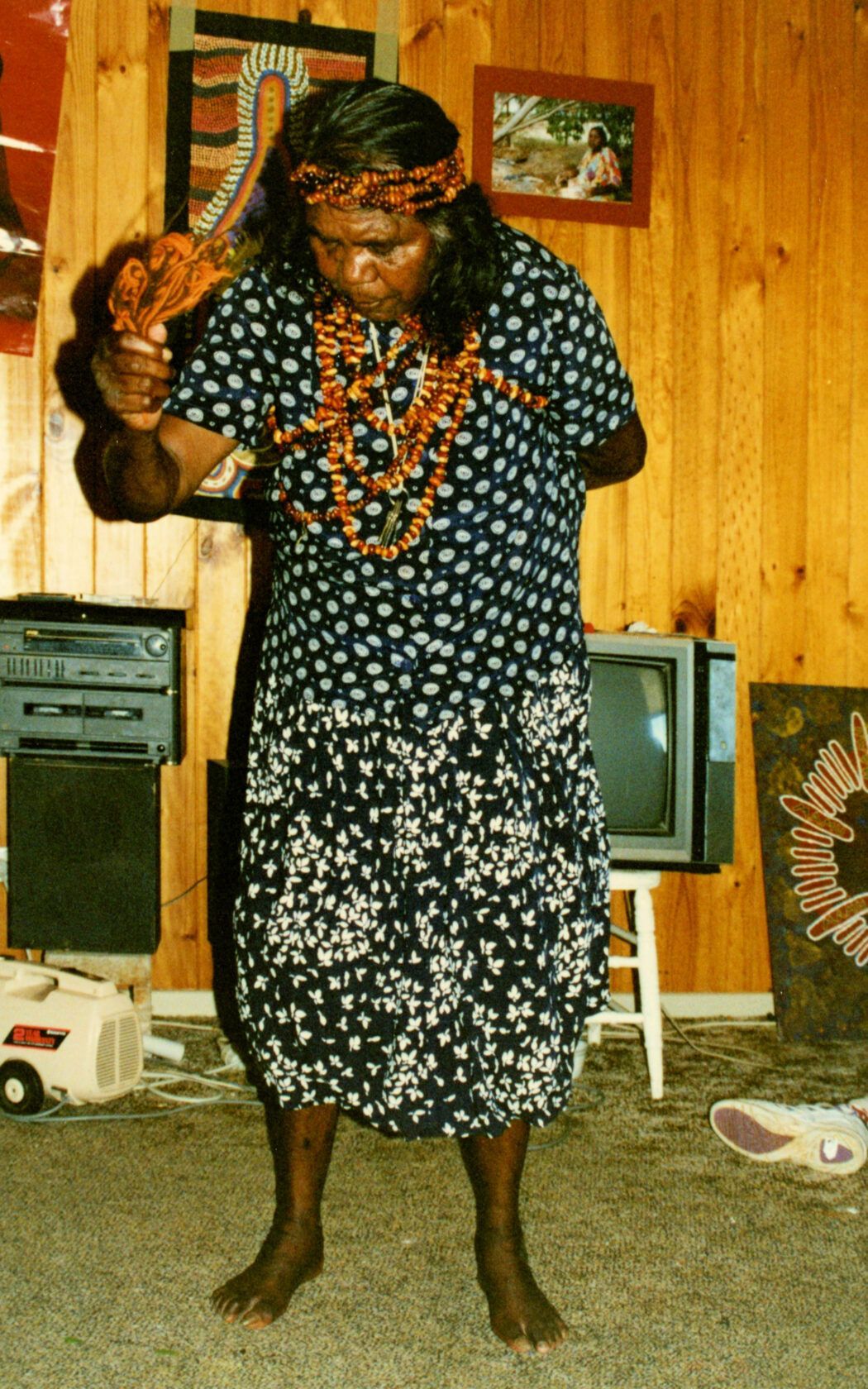 A man in a polka dot dress is standing in front of a tv