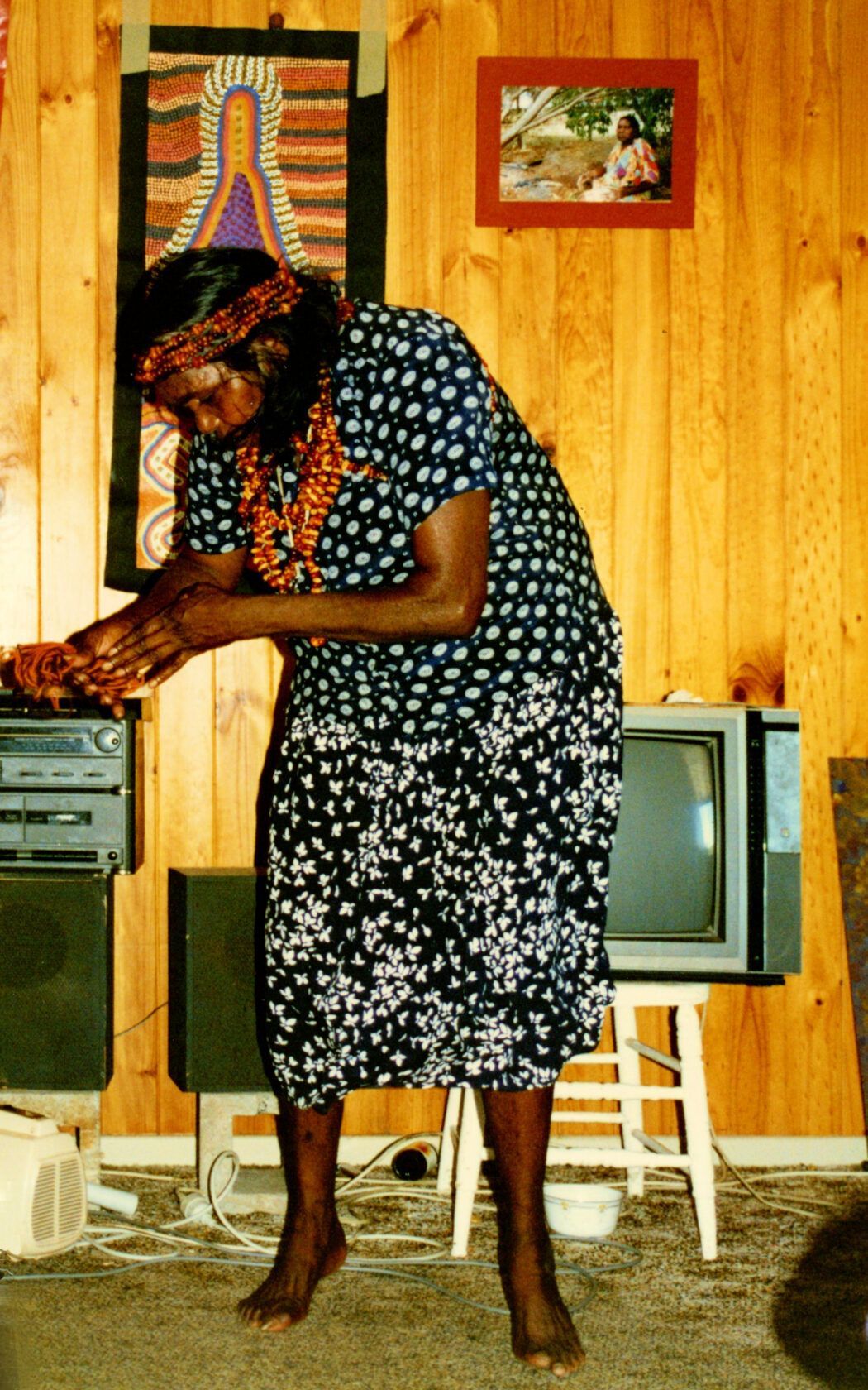 A woman in a polka dot dress is standing in front of a television