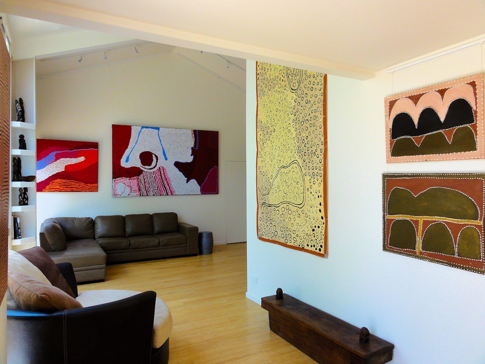 A living room with a couch and paintings on the wall