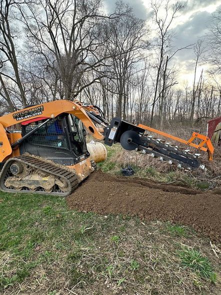 A bulldozer is digging a hole in the ground in a field.