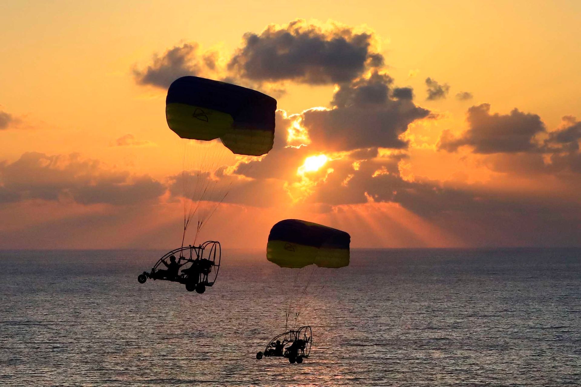 טרקטורון מעופף מעל חוף הים בשקיעה