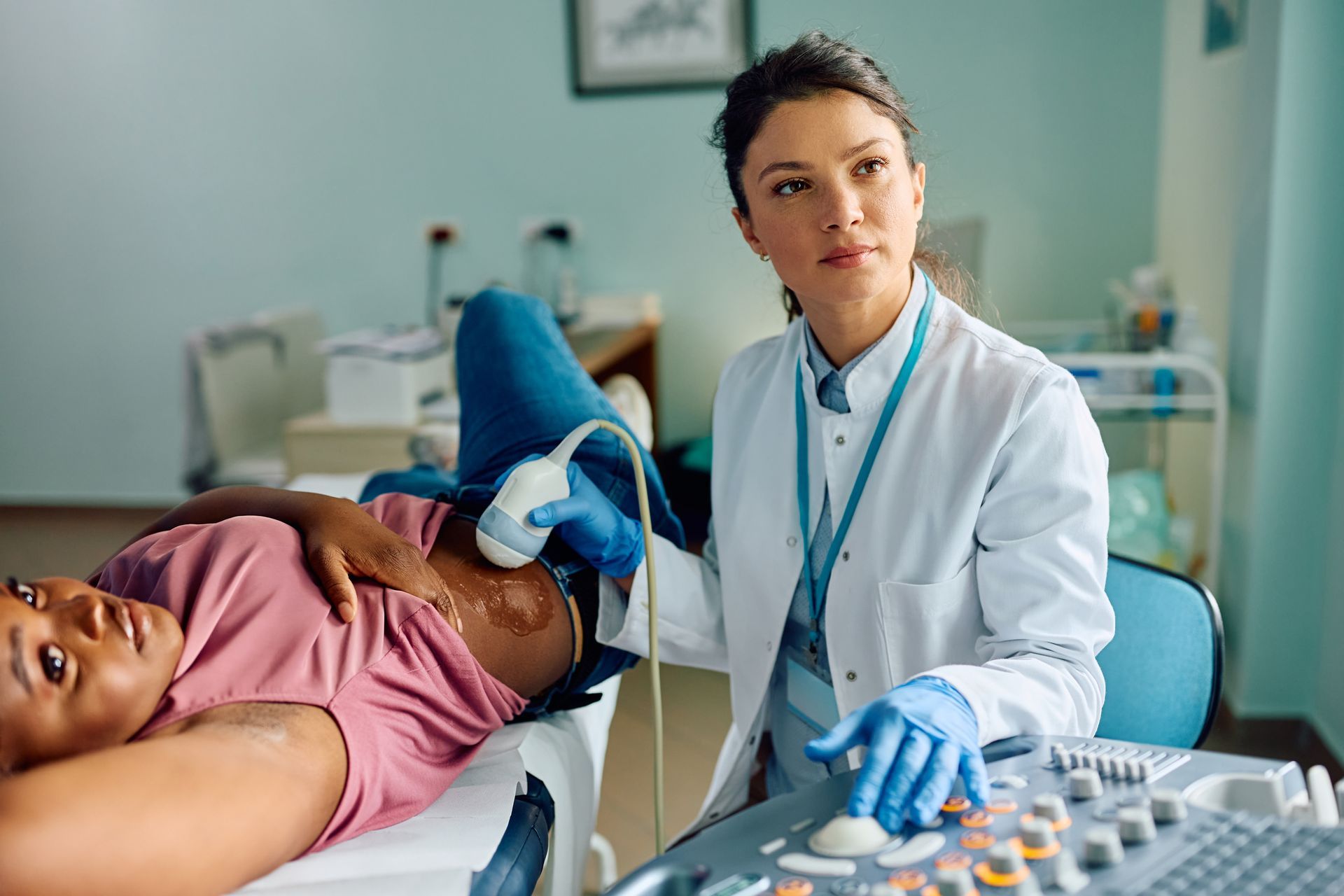Doctor examining patient with ultrasound in a clinic room