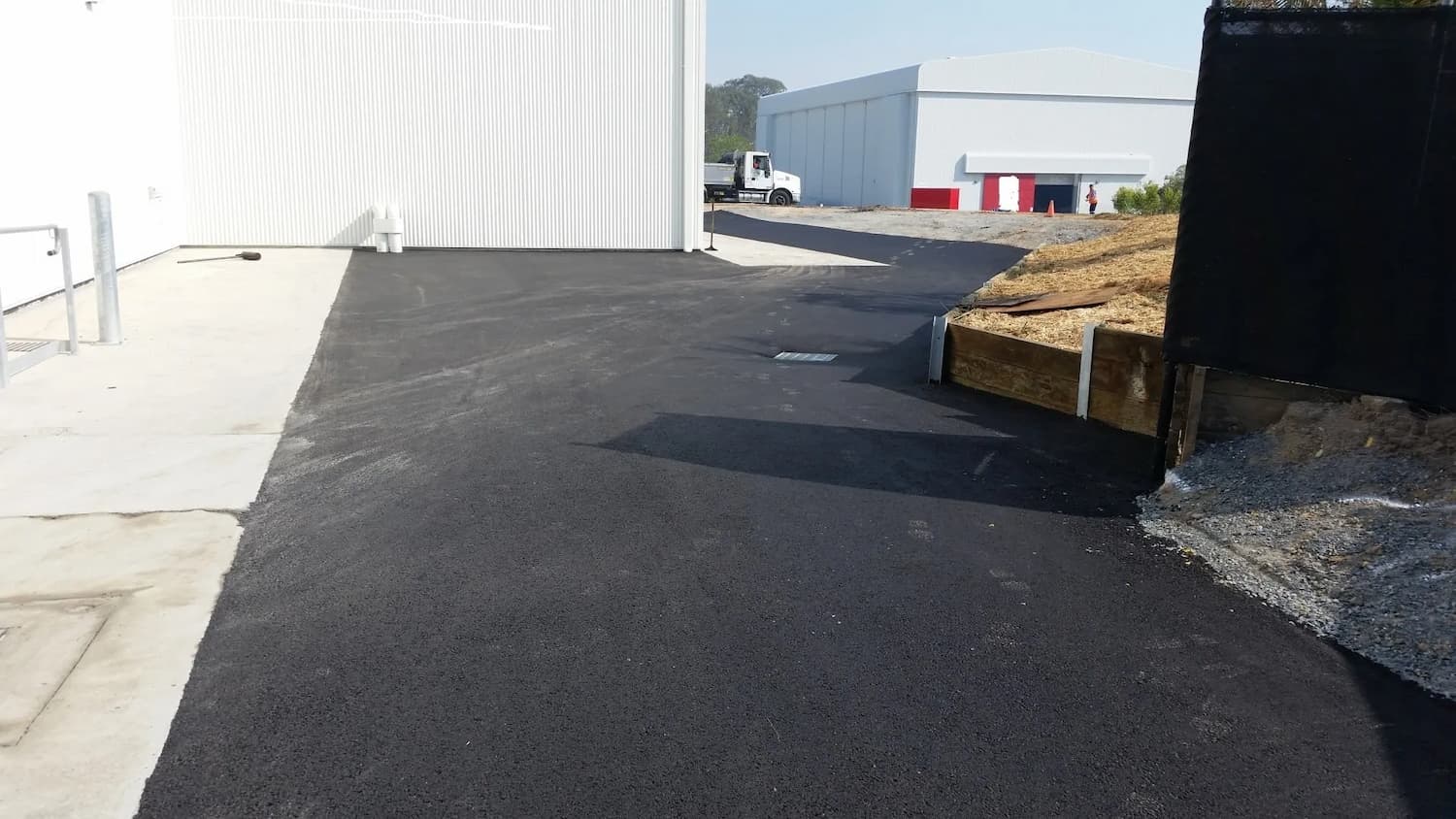 Long Asphalt Driveway to Warehouse — Asphalt and Concreting Services and Solutions in Logan Village, QLD