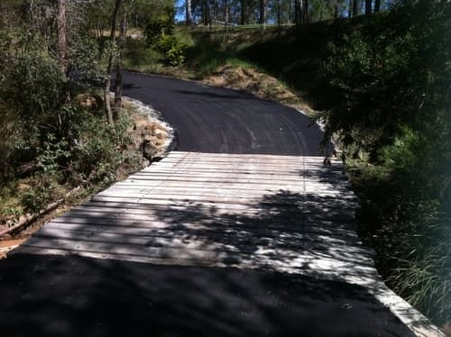 Wooden Bridge Connecting Asphalt Road — Asphalt and Concreting Services and Solutions in Logan Village, QLD