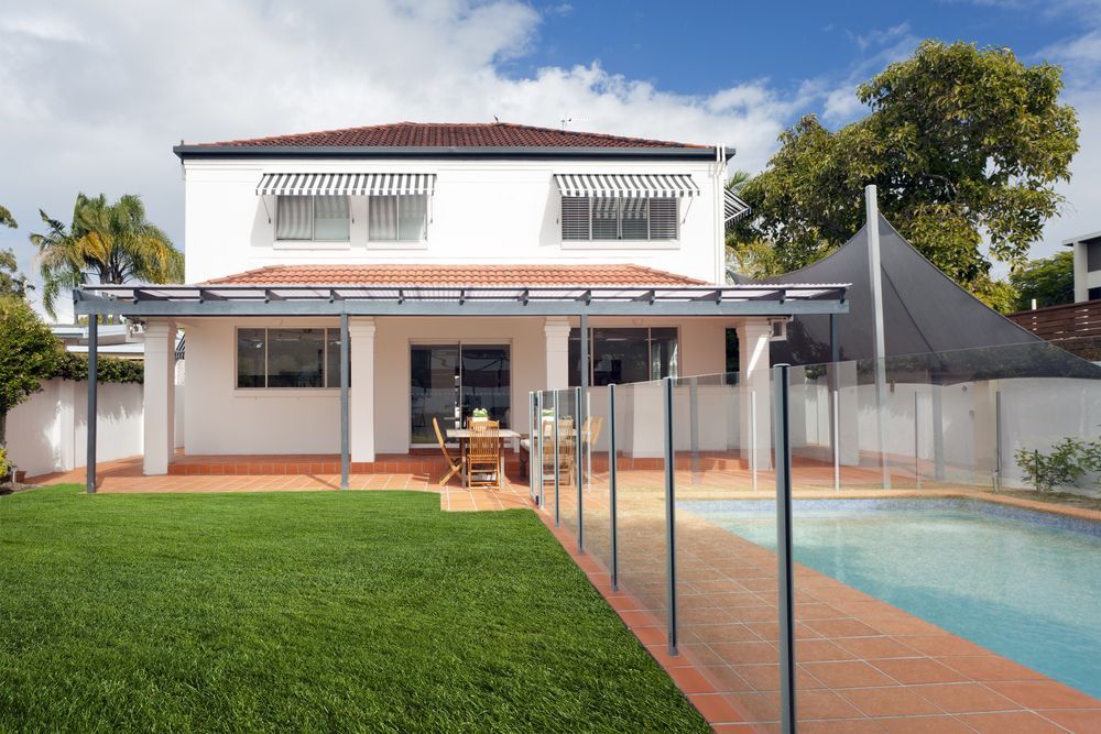 Two-Story White House with A Patio Overlooking a Pool and Grassy Yard — Sunshine Gates in Maroochydore, QLD