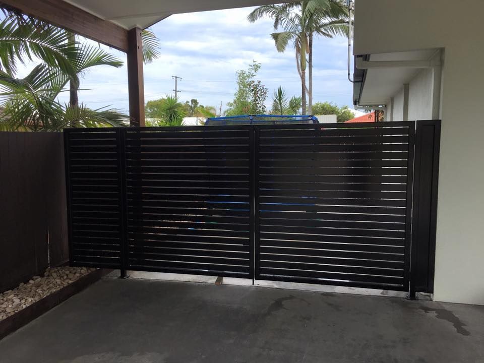 A Car is Parked in a Driveway Behind a Black Gate — Sunshine Gates in Kunda Park, QLD