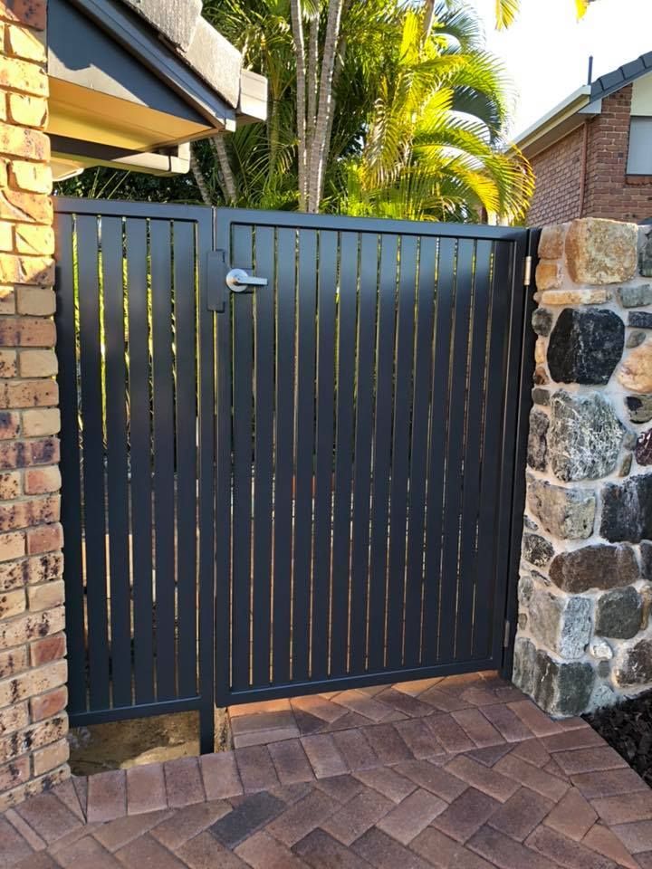 A Black Gate is Sitting Next to a Brick Wall — Sunshine Gates in Kunda Park, QLD