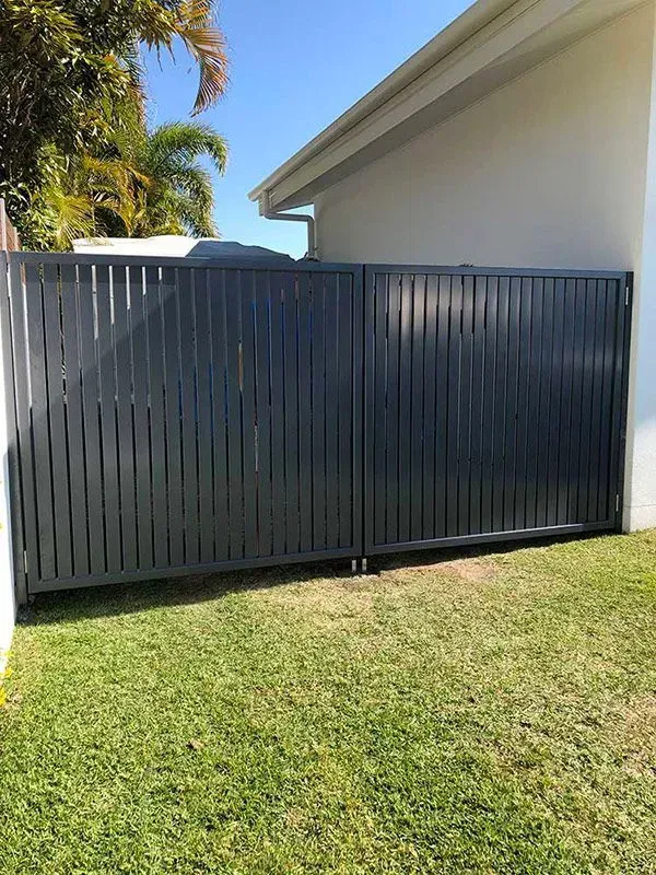 A Black Gate is Sitting Next to a Brick Wall — Sunshine Gates in Kunda Park, QLD
