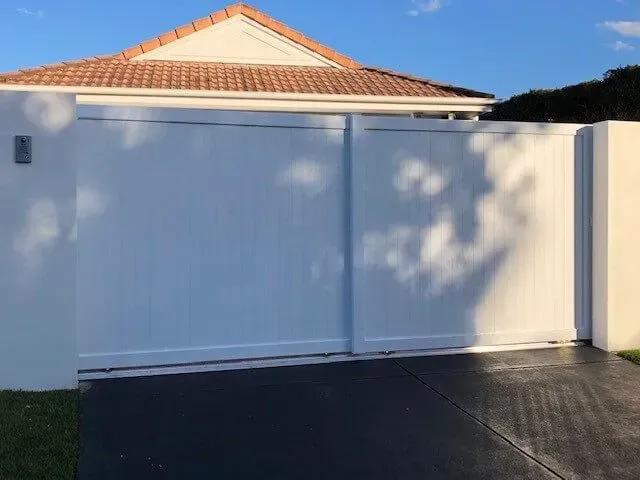 A white house with a sliding gate in front of it. — Sunshine Gates in Kunda Park, QLD