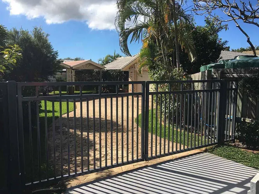 A Black Sliding Gate is Open in Front of a House A — Sunshine Gates in Caloundra, QLD