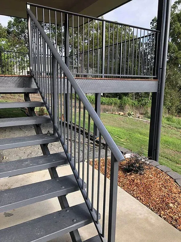 A set of stairs with a metal railing leading up to a balcony. — Sunshine Gates in Kunda Park, QLD