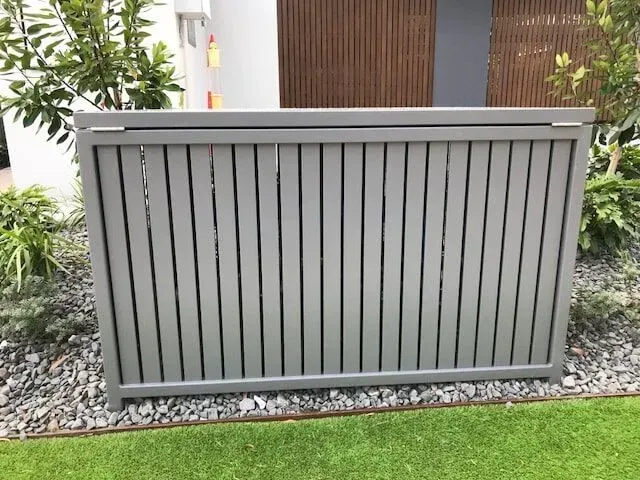 A gray fence is sitting on top of a lush green lawn in front of a house. — Sunshine Gates in Kunda Park, QLD