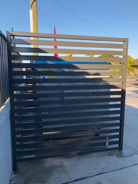 A fence with a car parked behind it. — Sunshine Gates in Kunda Park, QLD
