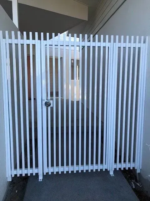 A white fence with a door that is open. — Sunshine Gates in Kunda Park, QLD