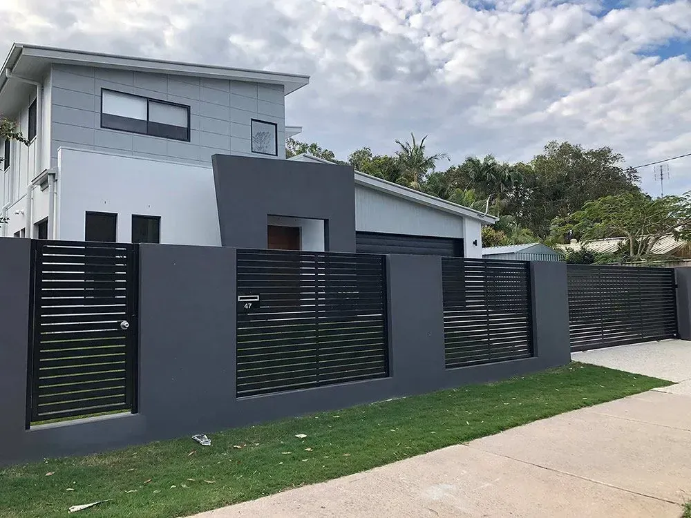 A white house with a black fence in front of it. — Sunshine Gates in Kunda Park, QLD