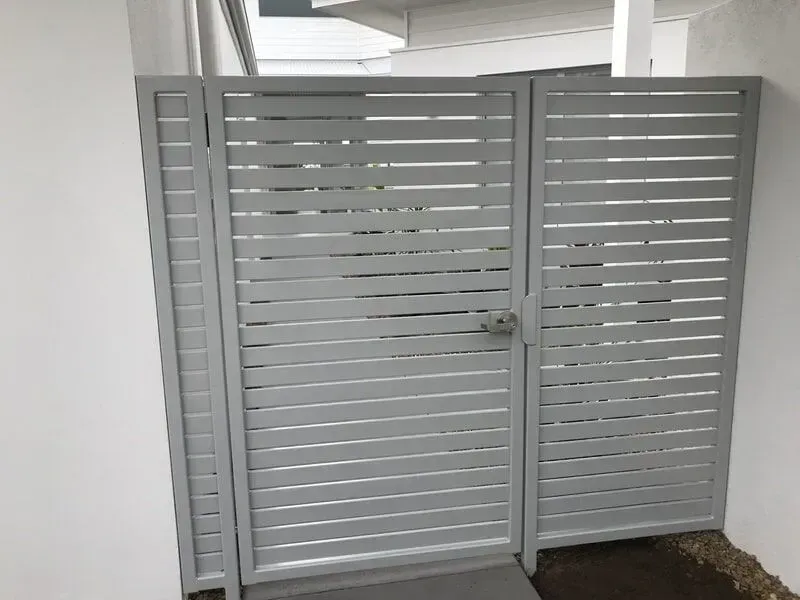 A white gate is sitting next to a white wall. — Sunshine Gates in Kunda Park, QLD