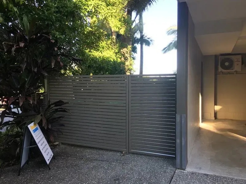A fence is surrounding a building with a sign in front of it. — Sunshine Gates in Kunda Park, QLD