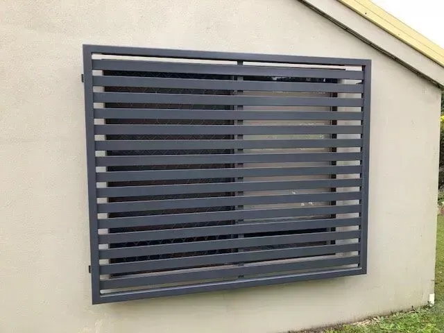 A window with a fence around it is on the side of a building. — Sunshine Gates in Kunda Park, QLD