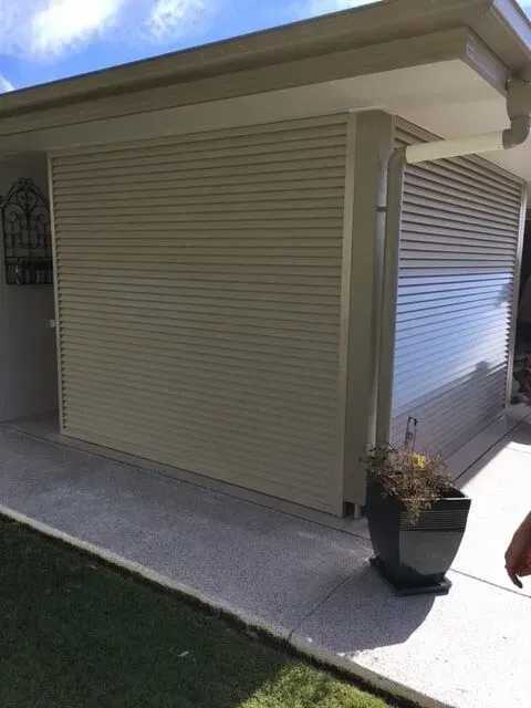 A white house with a potted plant in front of it.  — Sunshine Gates in Kunda Park, QLD