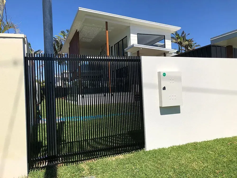 A white house with a black fence and a mailbox in front of it. — Sunshine Gates in Kunda Park, QLD