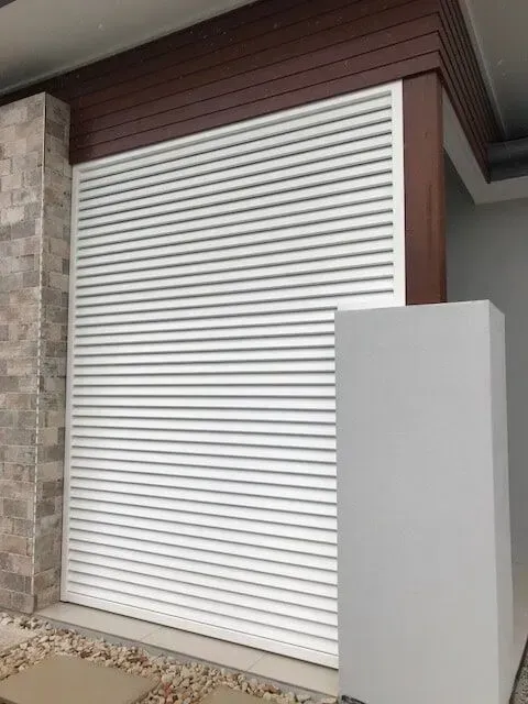 A white garage door is sitting on the side of a house. — Sunshine Gates in Kunda Park, QLD