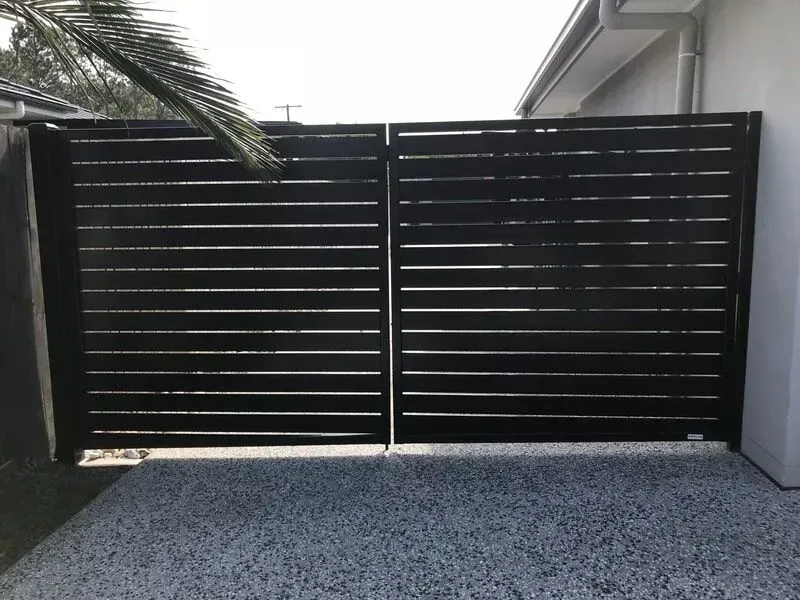 A black gate is sitting in front of a house. — Sunshine Gates in Kunda Park, QLD