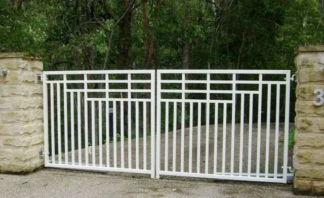 A white gate is surrounded by stone pillars and trees. — Sunshine Gates in Kunda Park, QLD