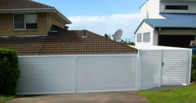A white garage door is in front of a house. — Sunshine Gates in Kunda Park, QLD