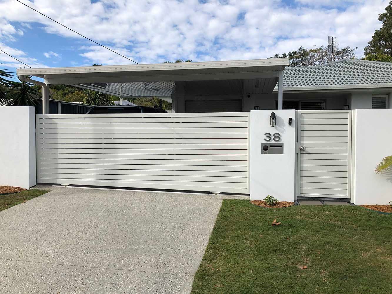 A white house with a white fence and a white gate — Sunshine Gates in Kunda Park, QLD