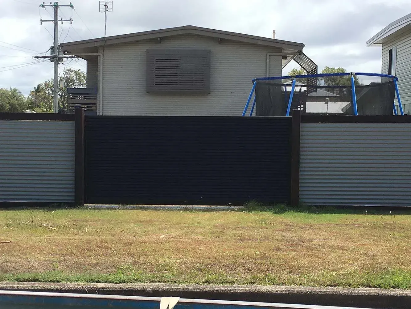A house with a swing set behind a fence next to a pool. — Sunshine Gates in Kunda Park, QLD