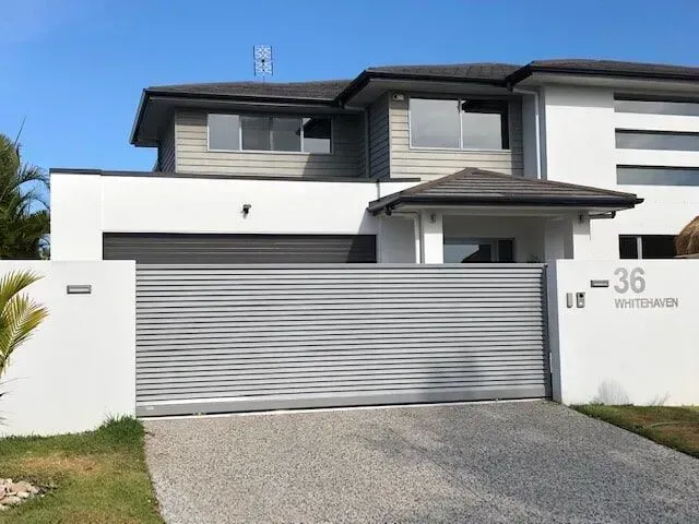 A large white house with a sliding garage door — Sunshine Gates in Kunda Park, QLD