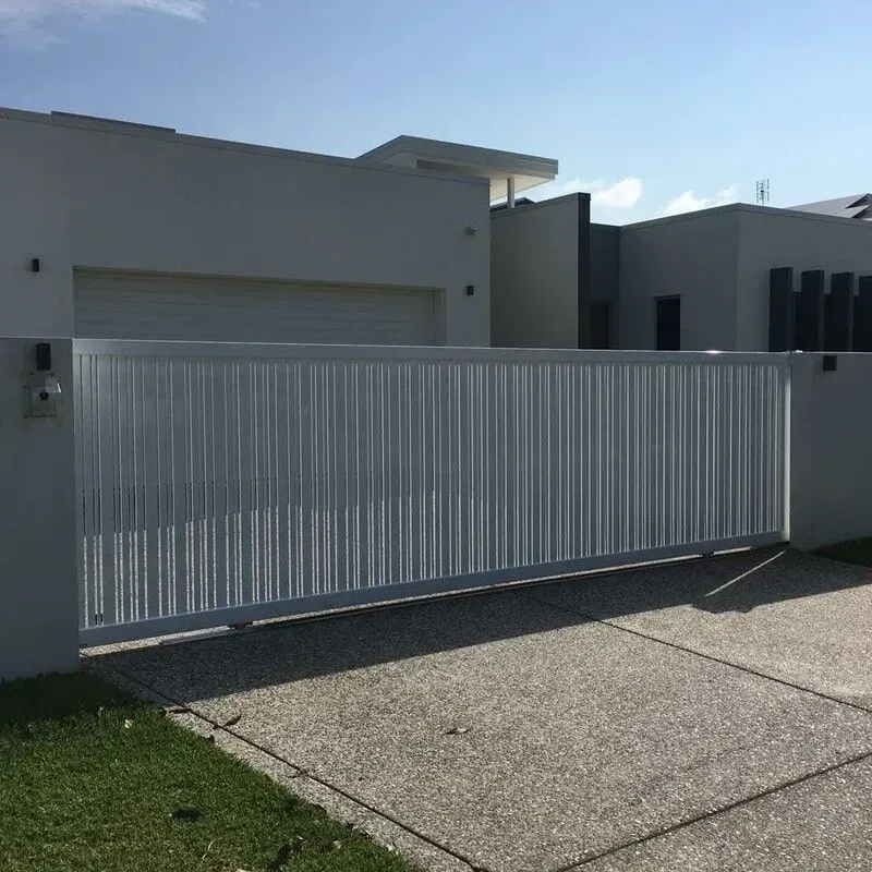 A white sliding gate is in front of a white house. — Sunshine Gates in Kunda Park, QLD
