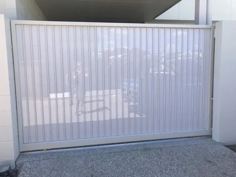 A white sliding gate is open to a driveway. — Sunshine Gates in Kunda Park, QLD