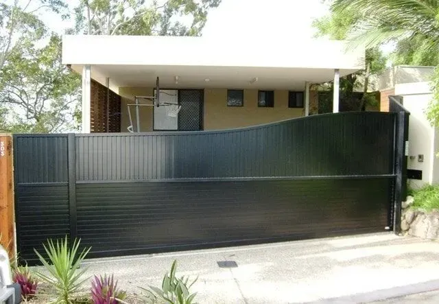 A house with a black sliding gate in front of it