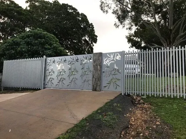 A white picket fence surrounds a driveway and a gate. — Sunshine Gates in Kunda Park, QLD