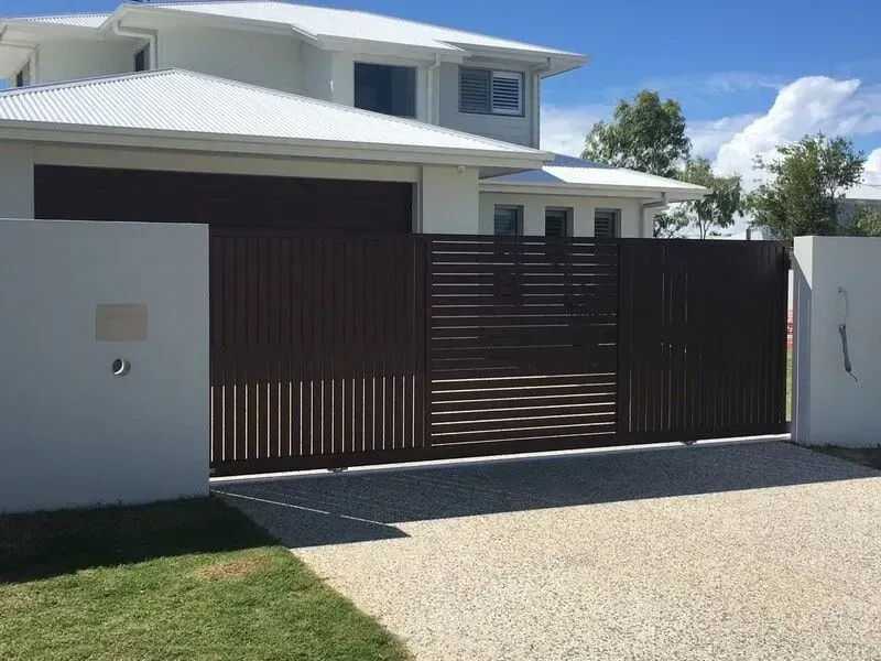A large white house with a brown sliding gate in front of it. — Sunshine Gates in Kunda Park, QLD