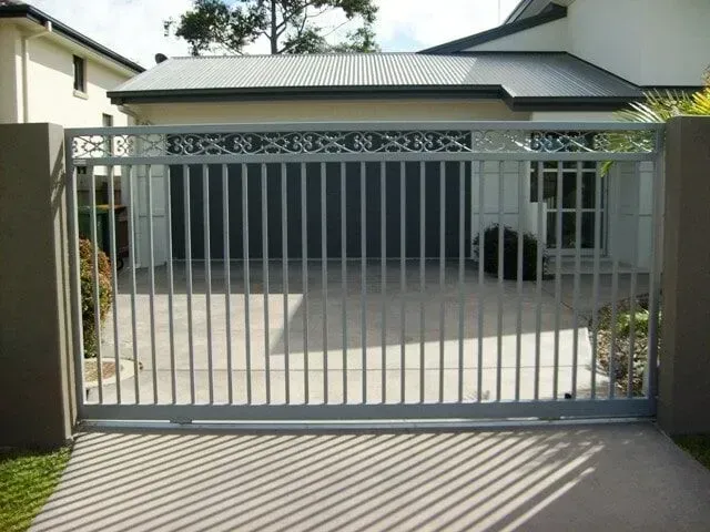 A sliding gate is open to a driveway in front of a house. — Sunshine Gates in Kunda Park, QLD