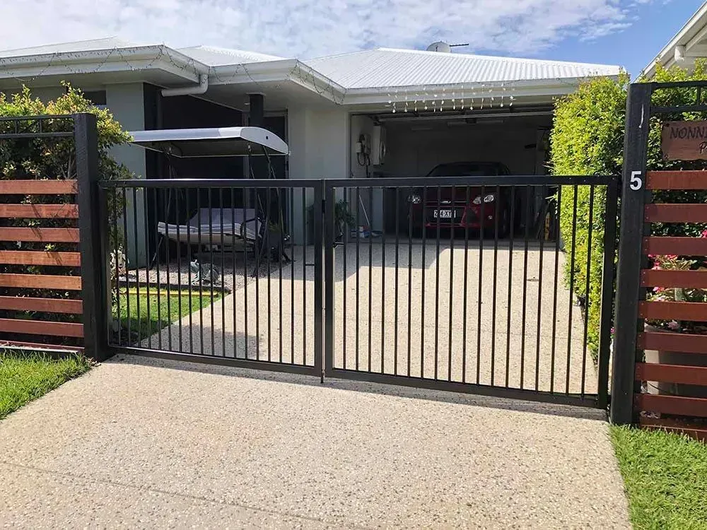 A car is parked in the driveway of a house behind a gate. — Sunshine Gates in Kunda Park, QLD